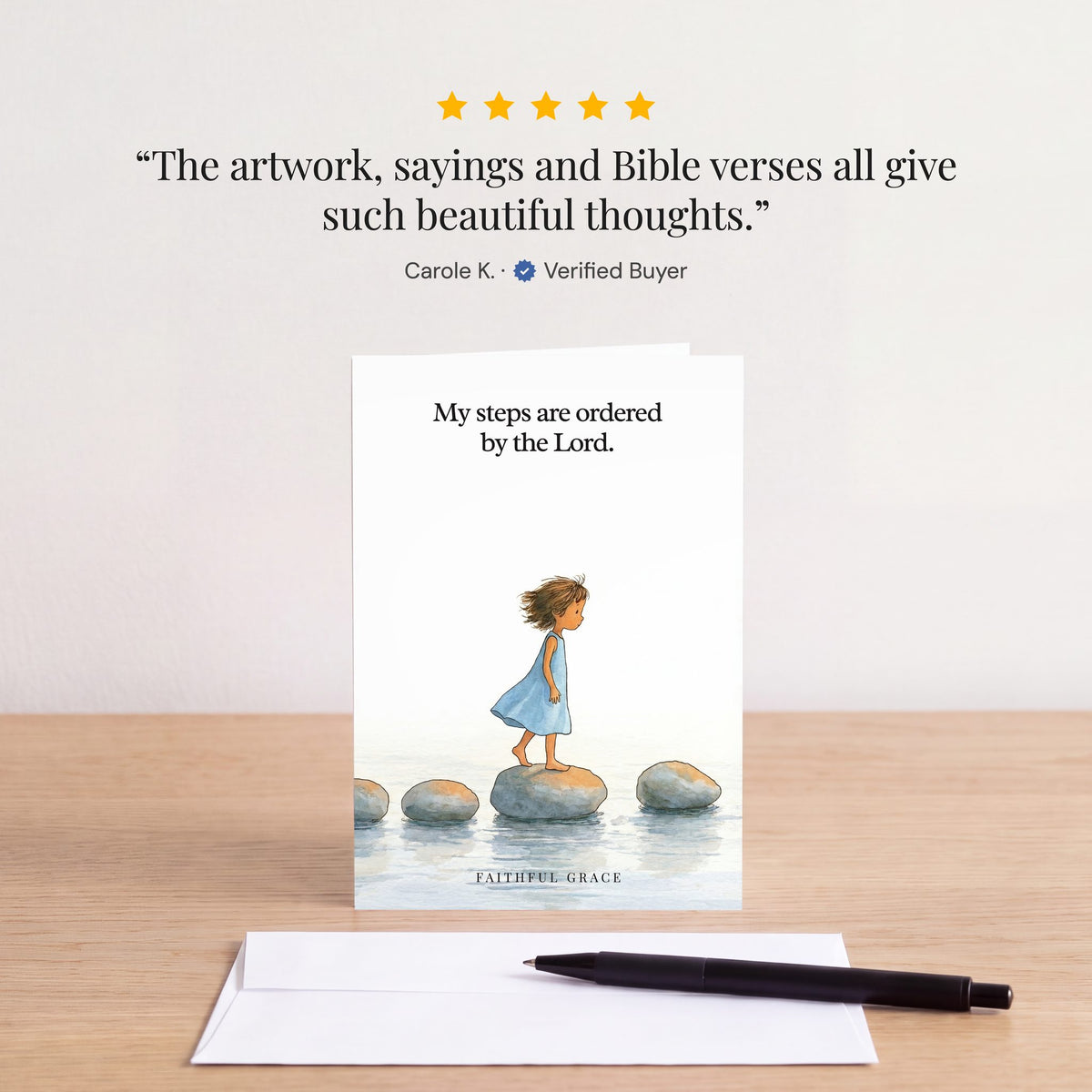 The Ordered by the Lord card on a table with a white envelope. Review: "The artwork, sayings and Bible verses all give such beautiful thoughts." Carole K.