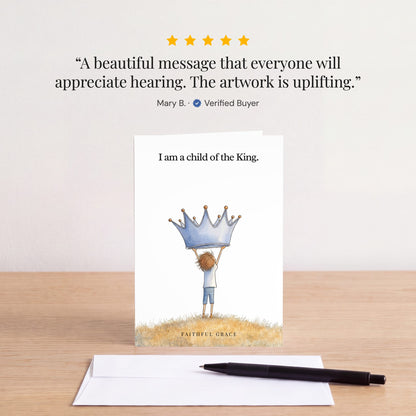 The Child of the King card on a table with a white envelope. Review: "A beautiful message that everyone will appreciate hearing. The artwork is uplifting." Mary B.