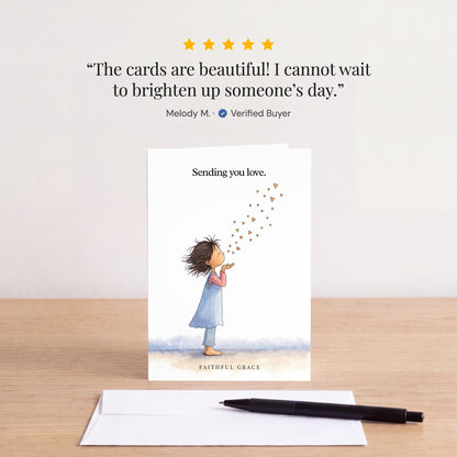 The Sending you love card on a table with a white envelope. Review: "The cards are beautiful! I cannot wait to brighten up someone’s day." Melody M.