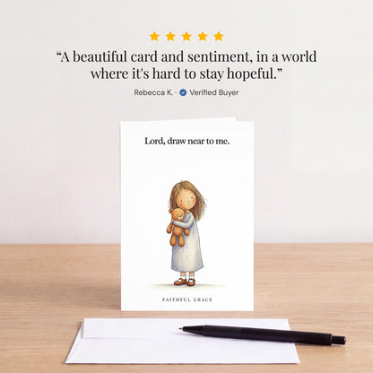 The Draw near to me card on a table with a white envelope. Review: "A beautiful card and sentiment, in a world where it's hard to stay hopeful." Rebecca K.