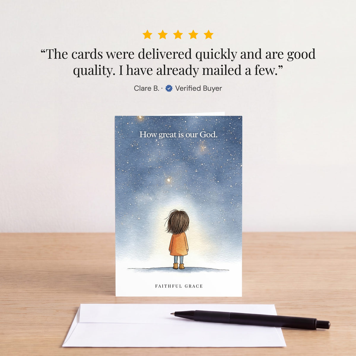 The How great is our God card on a table with a white envelope. Review: "The cards were delivered quickly and are good quality. I have already mailed a few." Clare B.