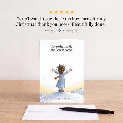 The Joy to the world card on a table with a white envelope. Review: "Can't wait to use these darling cards for my Christmas thank you notes. Beautifully done." Martha C.